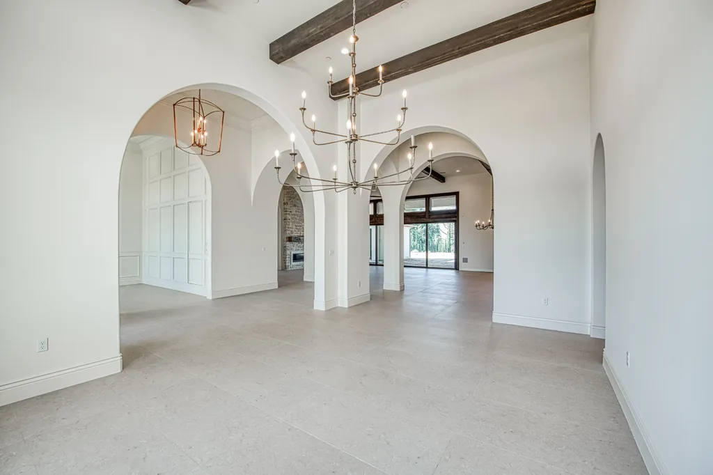 Interior of Willow Bluff Estate featuring layered arches, exposed beams, and chandeliers.