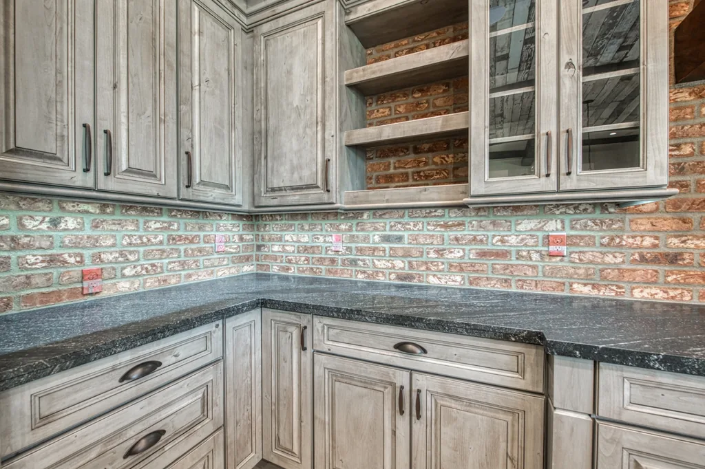 Custom glass-front cabinetry and tile detailing in the Devonshire Estate kitchen.