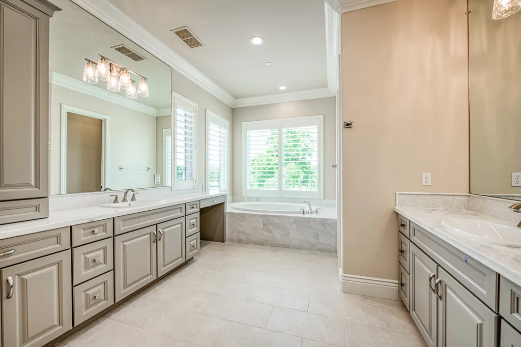 Primary bath at Devonshire Estate with dual vanities and a marble-surround soaking tub.
