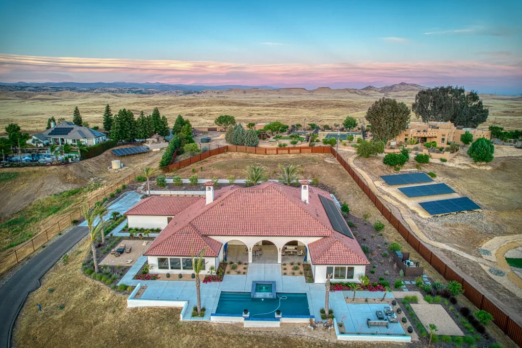 Evening aerial of the pool courtyard and tile-roofed wings at Friant Estate.