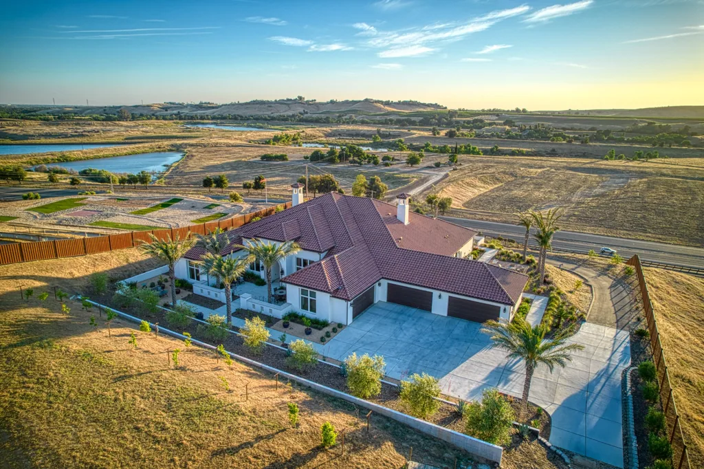 Aerial view of Friant Estate at dusk showing the tile-roofed custom home, pool, and surrounding Central Valley land in Friant, California.