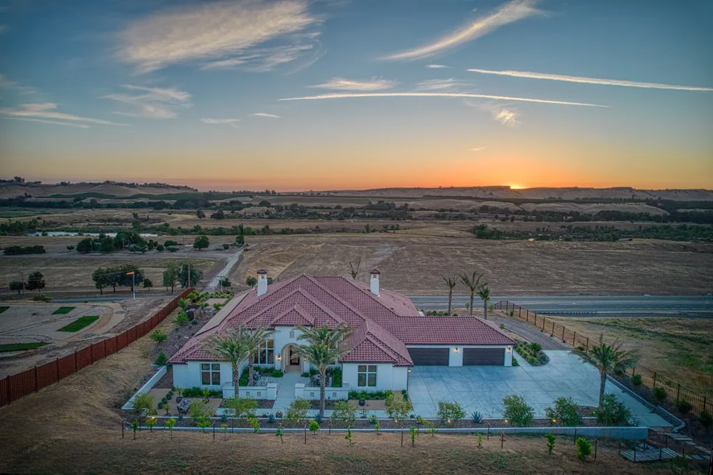Wide aerial sunset panorama of Friant Estate overlooking open foothill land.