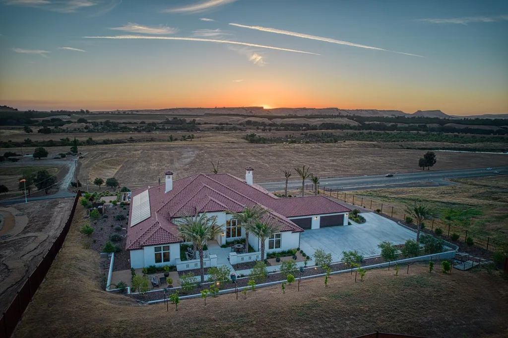 Aerial sunset view of Friant Estate and its landscaped rear yard in Friant, California.