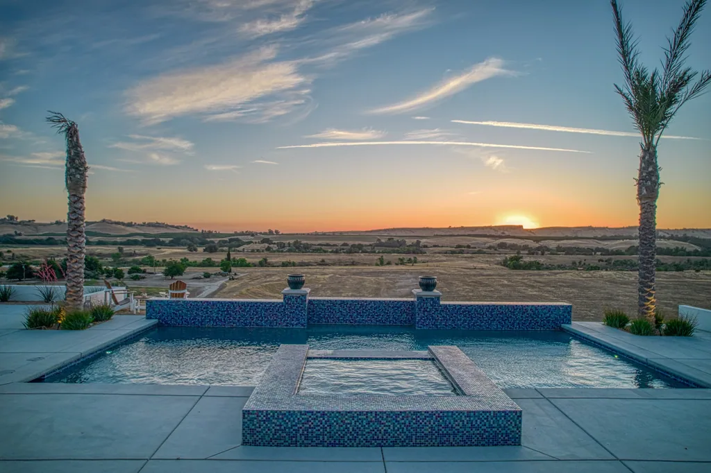 Pool water feature at Friant Estate silhouetted against a Central Valley sunset.