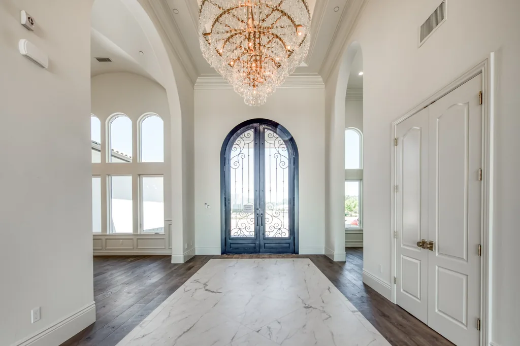 Entry foyer with arched black iron doors and marble floor inlay at Kings Estate.
