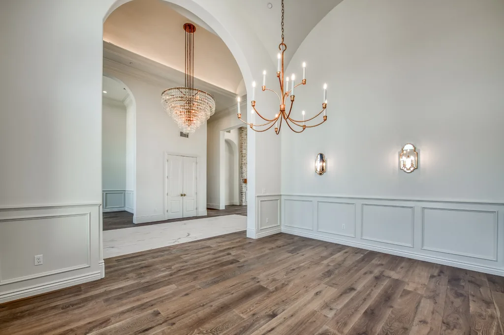 Formal dining room with crystal chandelier and arched entryways at Kings Estate.