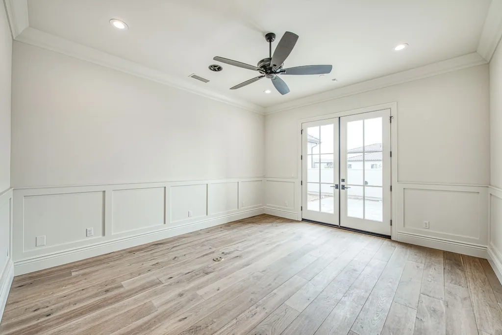 Formal room with white wainscoting and French doors to the courtyard.