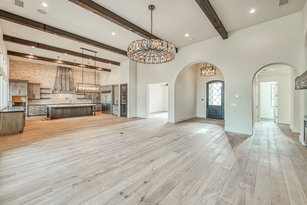 Great room open to the kitchen beneath heavy timber ceiling beams.