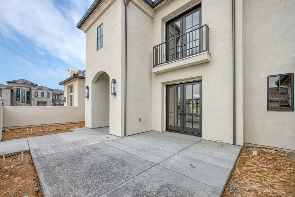Side elevation with wrought iron balcony and French doors.