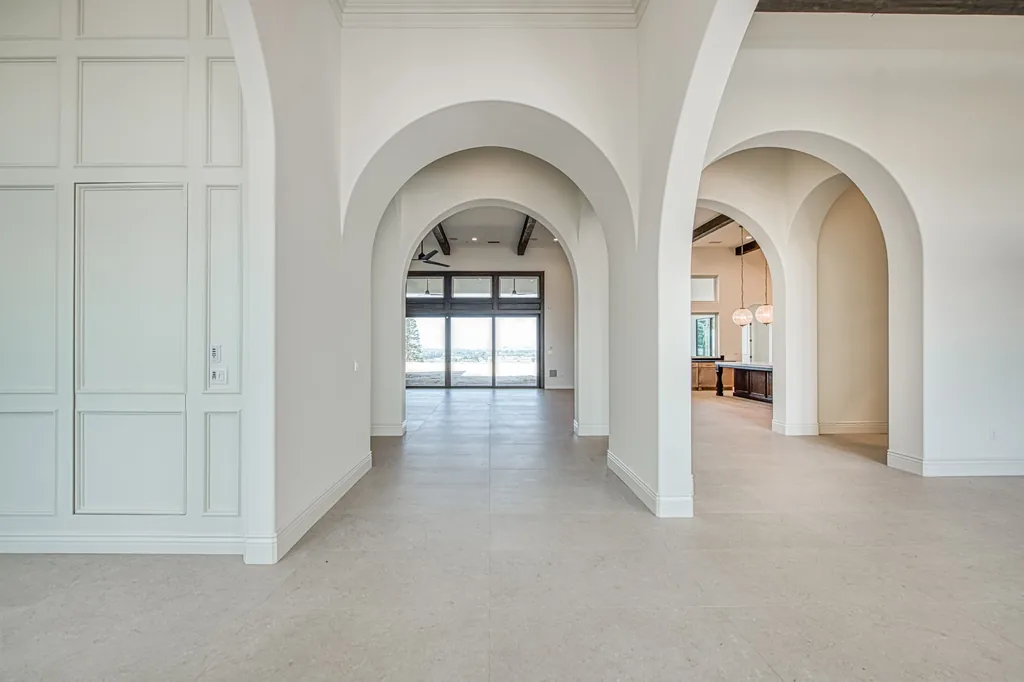 Foyer gallery framed by plaster arched openings looking toward the great room.