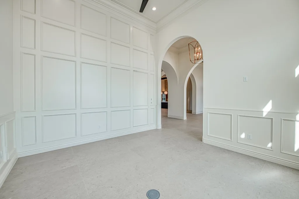 Hand-built paneled wall and wainscoting beside an arched hallway opening.