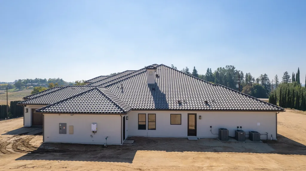 Rear elevation of Willow Bluff Estate with deep tile hip roof and covered service entry.