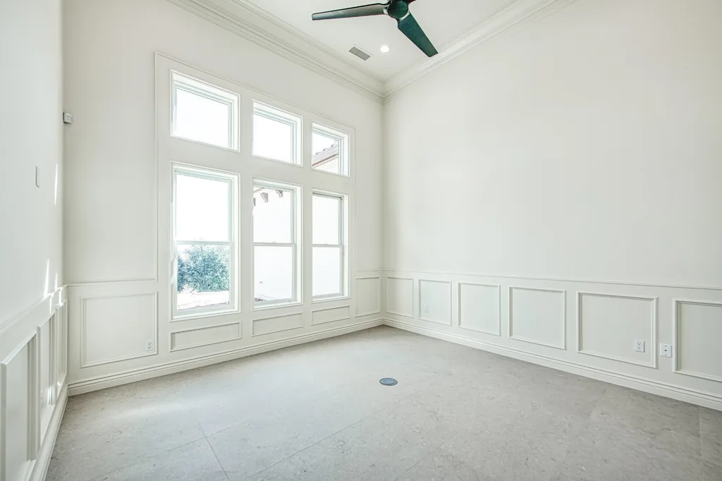 Study with painted wainscoting and a wall of tall windows.